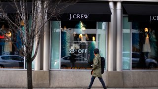 In this March 24, 2014, file photo, a pedestrian passes a J.Crew store in the Shadyside shopping district of Pittsburgh.