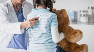 Doctor checking patient's heart beat