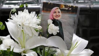 A photo of Summer Taylor, who suffered critical injuries and died after being hit by a car while protesting over the weekend, sits among flowers at the King County Correctional Facility where a hearing was held for the suspect in their death Monday, July 6, 2020, in Seattle. Dawit Kelete is accused of driving a car on to a closed Seattle freeway and hitting two protesters, killing one, over the weekend.