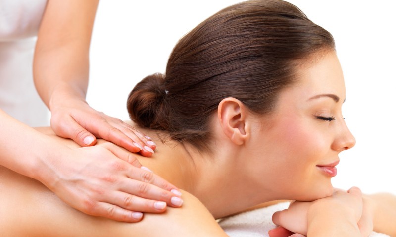 Young woman getting massage from female hands