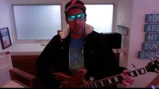 Adam Sandler performs a song on his guitar