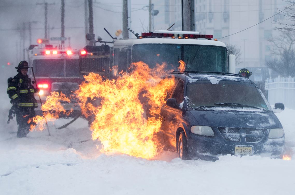 Firefighters extinguish a vehicle fire during a winter snowstorm in Atlantic City, N.J.