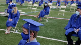 Graduating students practice socially distance by sitting far apart during a graduation ceremony at Millburn High School in Millburn, N.J., Wednesday, July 8, 2020. This week New Jersey saw the resumption of youth day camps, in-person summer school and school graduation ceremonies, capped at 500 people and required to be outside.