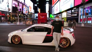 In this Saturday, May 2, 2020, file photo, Danny Lin poses with his 2008 Audi R8 in New York's Times Square during the coronavirus pandemic. "I never bring my car here," said the 24-year-old from Queens. "Only for today, to get some cool shots."