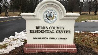 A sign reads "Berks County Residential Center." Underneath are the words immigration family center"