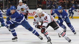 In this Jan. 18, 2020, file photo, Jonathan Toews #19 of the Chicago Blackhawks breaks between Timothy Liljegren #37 and Rasmus Sandin #38 of the Toronto Maple Leafs during an NHL game at Scotiabank Arena in Toronto, Ontario, Canada.