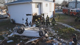 car lies upside down next to house