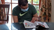A resident at the Bladt Residence in Flushing, Queens, reads while wearing a mask.