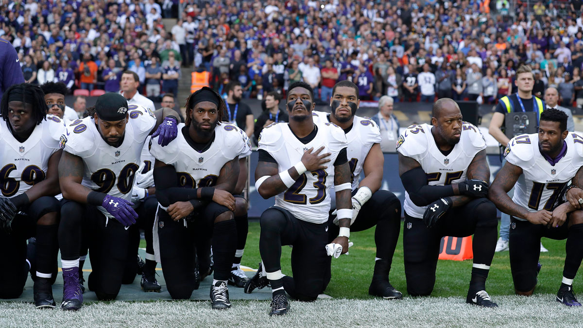 Baltimore Ravens players kneel down during the playing of the national anthem before an NFL football game against the Jacksonville Jaguars at Wembley Stadium in London, Sunday, Sept. 24, 2017.