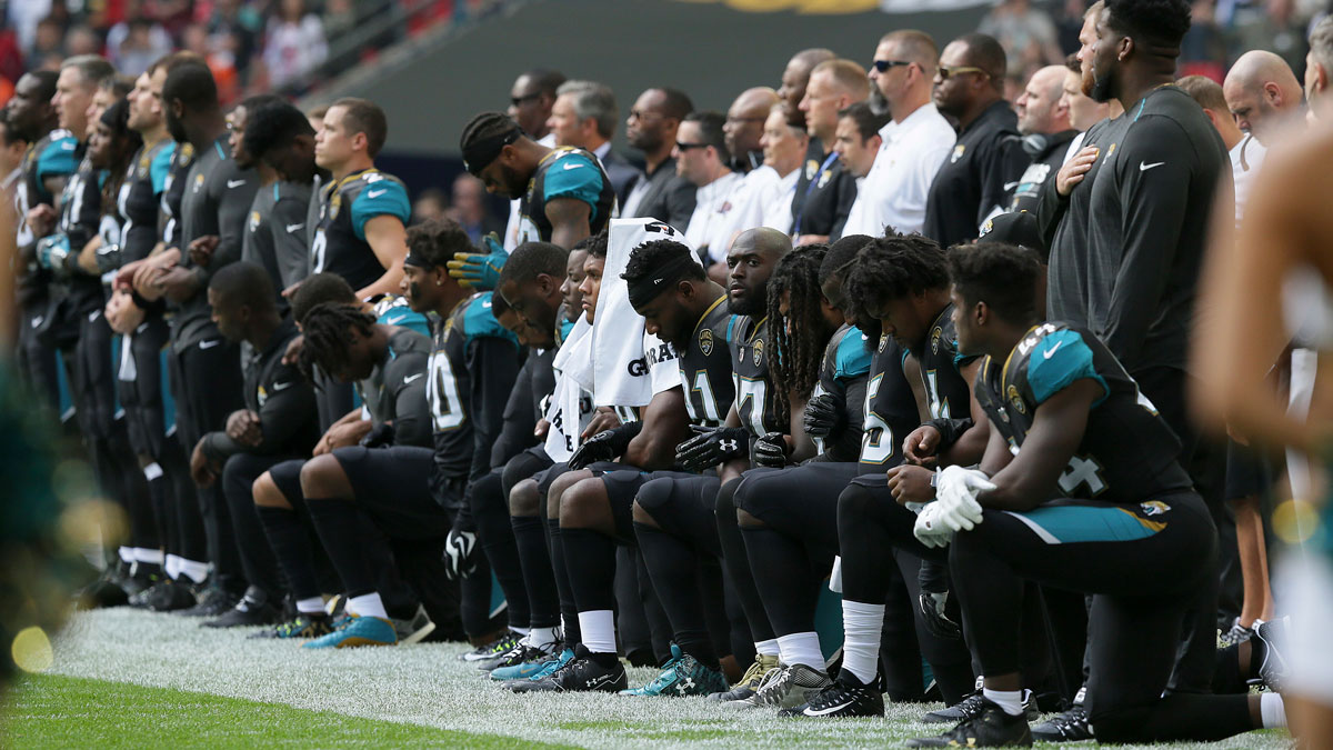 Jacksonville Jaguars players kneel down during the playing of the national anthem before an NFL football game against the Baltimore Ravens at Wembley Stadium in London, Sunday, Sept. 24, 2017.