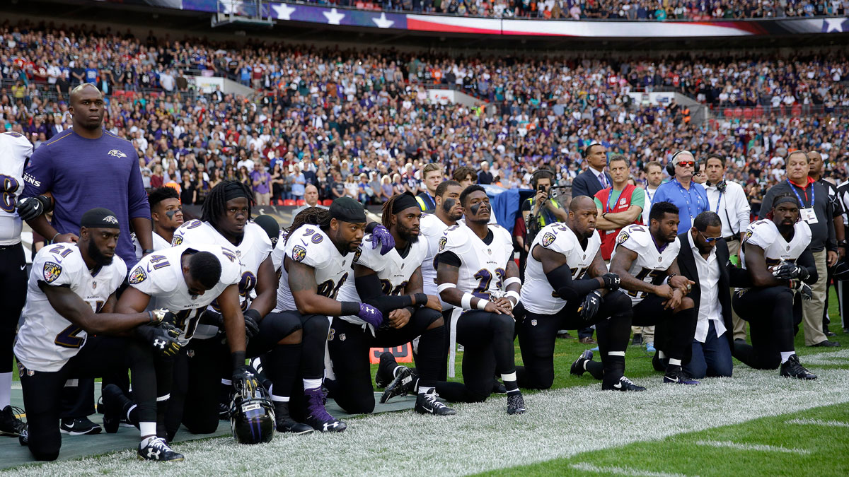 Baltimore Ravens players, including former player Ray Lewis, second from right, kneel down during the playing of the national anthem before an NFL football game against the Jacksonville Jaguars at Wembley Stadium in London, Sunday, Sept. 24, 2017.