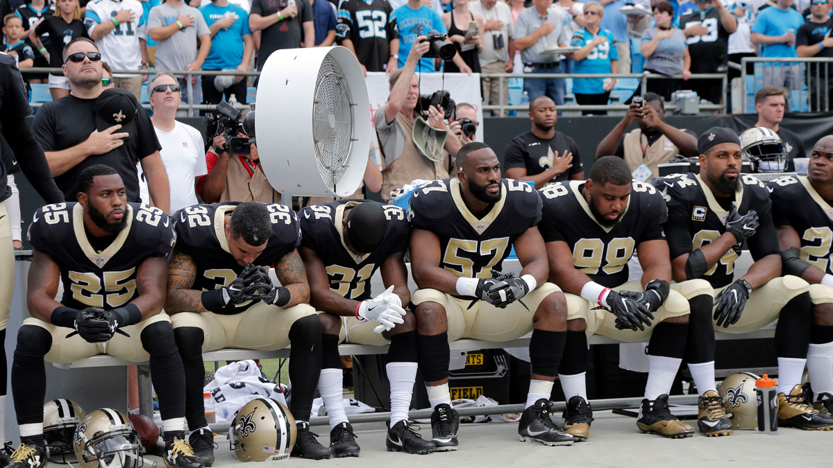 New Orleans Saints players sit on the bench during the national anthem before an NFL football game against the Carolina Panthers in Charlotte, N.C., Sunday, Sept. 24, 2017.