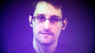 In this Dec. 10, 2014, file photo, former U.S. National Security Agency contractor Edward Snowden, who is in Moscow, is seen on a giant screen during a live video conference for an interview as part of Amnesty International's annual Write for Rights campaign at the Gaite Lyrique in Paris, France.