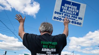 Protesters against the death penalty gather in Terre Haute, Ind., Monday, July 13, 2020. Daniel Lewis Lee, a convicted killer, was scheduled to be executed at 4 p.m. in the federal prison in Terre Haute. He was convicted in Arkansas of the 1996 killings of gun dealer William Mueller, his wife, Nancy, and her 8-year-old daughter, Sarah Powell.