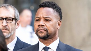 FILE – Actor Cuba Gooding Jr. listens as attorney Mark Heller addresses press after Gooding’s arraignment before the New York State Supreme Court, Oct. 15, 2019, in Manhattan.