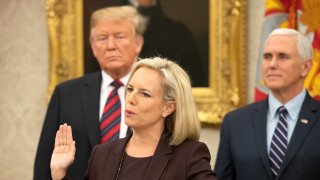 WASHINGTON, DC - JANUARY 19: United States Secretary of Homeland Security (DHS) Kirstjen Nielsen, center, administers the oath of citizenship to five people as U.S. President Donald Trump, left, and Vice President Mike Pence, right look on during a naturalization ceremony in the Oval Office of the White House in Washington, DC on Saturday, January 19, 2019.