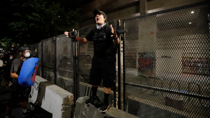 A demonstrator rallies a crowd in front of a steel fence during a Black Lives Matter protest at the Mark O. Hatfield United States Courthouse Tuesday, July 28, 2020, in Portland, Oregon.