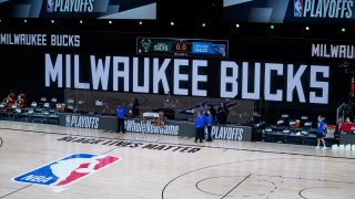 In this Aug. 26, 2020, file photo, officials stand beside an empty court after the scheduled start of game five between the Milwaukee Bucks and the Orlando Magic in the first round of the 2020 NBA Playoffs at AdventHealth Arena at ESPN Wide World Of Sports Complex in Lake Buena Vista, Florida. According to reports, the Milwaukee Bucks have boycotted their game 5 playoff game against the Orlando Magic to protest the shooting of Jacob Blake by Kenosha, Wisconsin police. NOTE TO USER: User expressly acknowledges and agrees that, by downloading and or using this photograph, User is consenting to the terms and conditions of the Getty Images License Agreement.