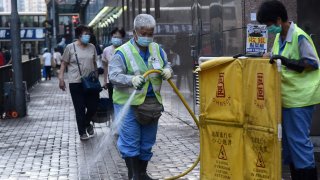 A sanitation worker cleans the street in Mong Kok amid the coronavirus outbreak on August 16, 2020, in Hong Kong, China.