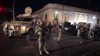 Police officers keeps watch as people are arrested after the start of a city-wide curfew outside of the Kenosha County Courthouse on August 29, 2020 in Kenosha, Wisconsin.