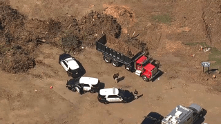 Police officers investigate scene of fatal dump truck incident