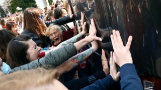 Women block a police bus during an opposition rally to protest the official presidential election results in Minsk, Belarus