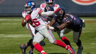 New York Giants running back Saquon Barkley (26) battles with Chicago Bears defensive tackle John Jenkins (90)