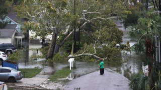 A person looks at a flooded neighborhood as Hurricane Sally passes through the area on September 16, 2020 in Pensacola, Florida. The storm is bringing heavy rain, high winds and a dangerous storm surge to the area.