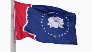 One of five final designs for the new Mississippi state flag flutters in the breeze, outside the Old Capitol Museum in Jackson, Miss., Aug. 25, 2020, in Jackson, Miss.