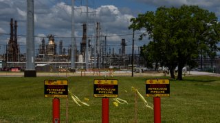 In this Aug. 24, 2020, file photo, signs read "Warning Petroleum Pipeline" at the Total SE refinery in Port Arthur, Texas.