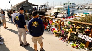 Members of the FBI dive team view a growing memorial.