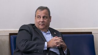 Former New Jersey Governor Chris Christie sits at the White House press room