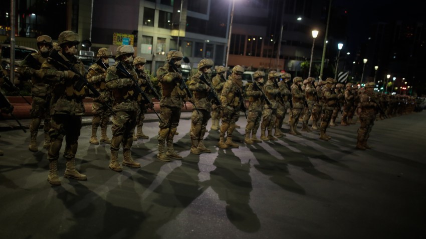 Military officers wearing facemasks stand guard during the start of a police patrol ahead of general elections on October 17, 2020 in La Paz, Bolivia.