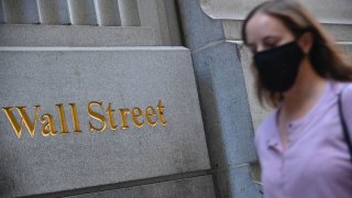 People walk by the New York Stock Exchange (NYSE) in lower Manhattan, Oct. 5, 2020, in New York City.