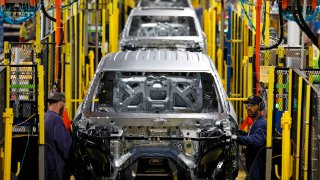 Workers assemble cars at the newly renovated Ford's Assembly Plant in Chicago