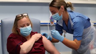 Deputy charge nurse Katie McIntosh administers the first of two Pfizer/BioNTech COVID-19 vaccine jabs, to Vivien McKay Clinical Nurse Manager at the Western General Hospital, on the first day of the largest immunisation programme in the British history, in Edinburgh, Scotland Britain Decembe