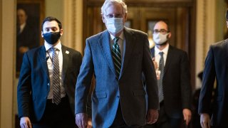 Senate Majority Leader Mitch McConnell, a Republican from Kentucky, center, wears a protective mask while returning to his office at the U.S. Capitol in Washington, D.C., on Thursday, Dec. 10, 2020.