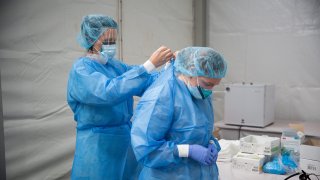 Members of the One Medical Group Inc. medical staff put on personal protective equipment