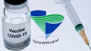 A bottle reading "Vaccine COVID-19" next to Chinese National Pharmaceutical Sinopharm logo