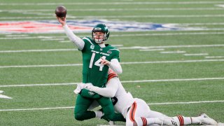 Sam Darnold #14 of the New York Jets throws away the ball as he is tackled by Myles Garrett #95 of the Cleveland Browns in the fourth quarter