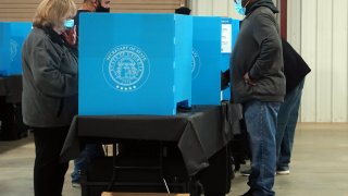 Georgia voters mark their ballots during the first day of early voting in the US Senate runoffs at the Gwinnett County Fairgrounds, Dec. 14, 2020, in Atlanta, Georgia.