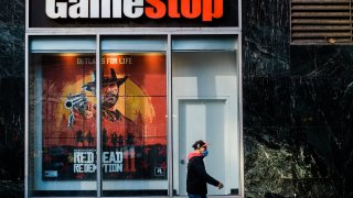 A pedestrian wearing a protective mask walks past a a GameStop Corp. store in the Herald Square area of New York, U.S., on Friday, Nov. 27, 2020.
