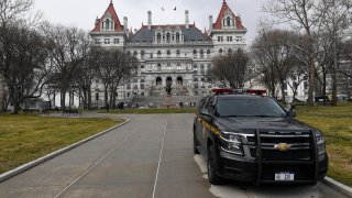 New York State Police patrol the grounds of the state Capitol