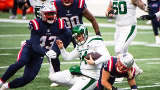 Sam Darnold #14 of the New York Jets is tackled by Rashod Berry #43 of the New England Patriots