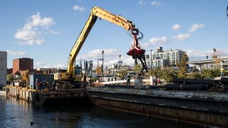 A work crew contracted by the Environmental Protection Agency removes debris from the Gowanus Canal