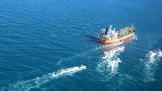 In this photo released Monday, Jan. 4, 2021, by Tasnim News Agency, the MT Hankuk Chemi, a South Korean-flagged tanker is escorted by Iranian Revolutionary Guard boats on the Persian Gulf. Iranian state television acknowledged that Tehran seized the oil tanker in the Strait of Hormuz. The report on Monday alleged the MT Hankuk Chemi had been stopped by Iranian authorities over alleged “oil pollution” in the Persian Gulf and the strait.