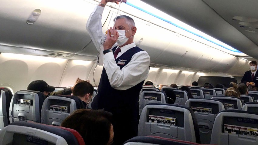 Flight attendants show safety precautions on an American Airlines Boeing 737 MAX airplane before it takes off on a test flight from Dallas-Fort Worth International Airport in Dallas, Texas, on December 2, 2020.