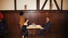 Wax statues of Audrey Hepburn and Michael Strahan occupy one of the tables at Peter Luger Steakhouse on Friday, Feb, 26, 2021, in New York. Five statues, on loan from Madame Tussauds, will occupy unused tables during COVID-19 occupancy restrictions. (AP Photo/Kevin Hagen)