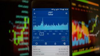 A smartphone displays the Tether market value on the stock