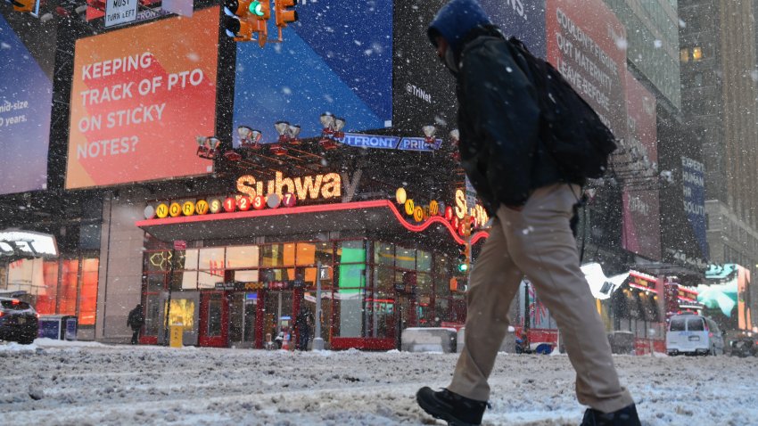 A man walks in Times Square during a winter storm
